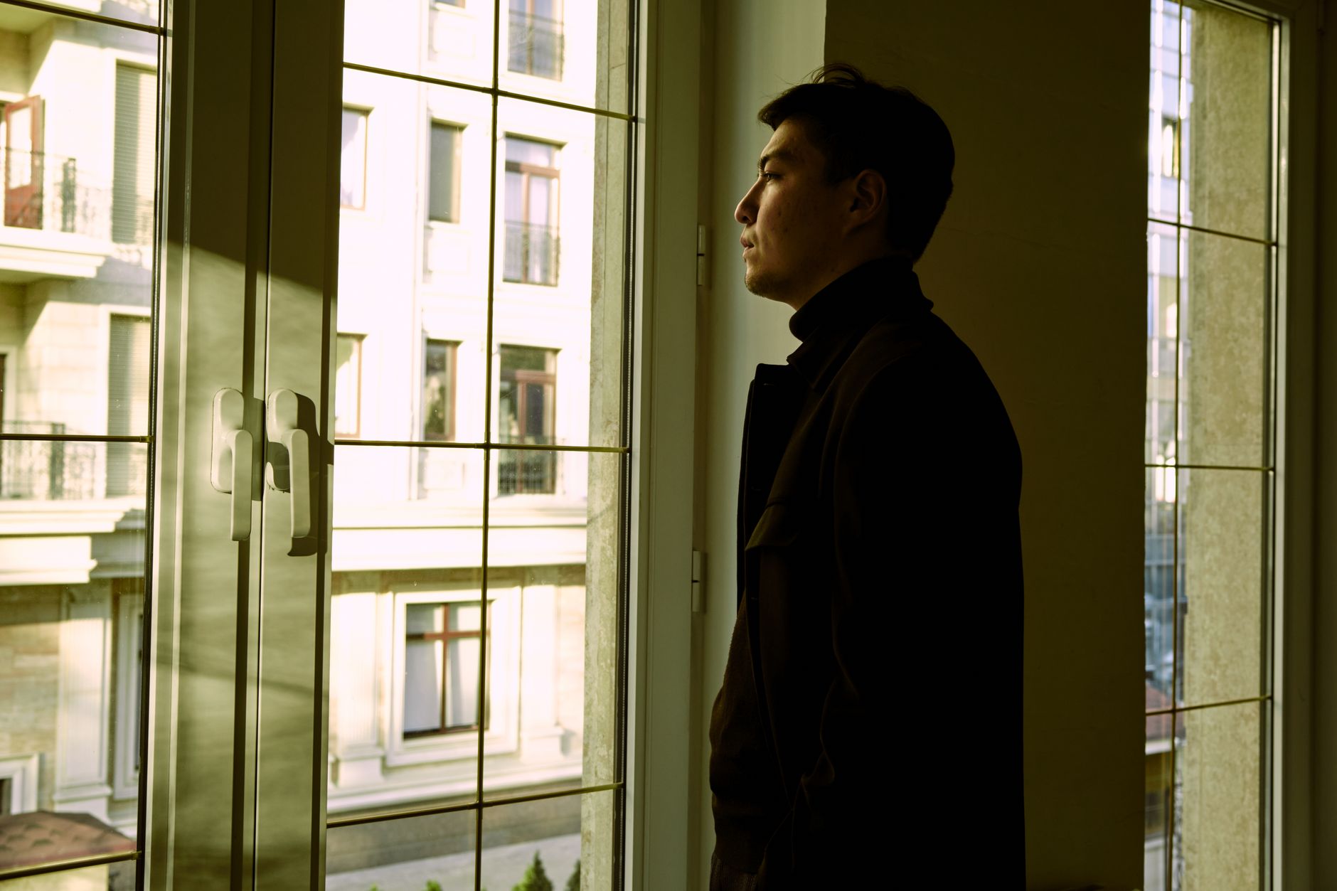 창가에 서서 바깥을 바라보는 남자
